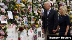 조 바이든(왼쪽) 미국 대통령과 부인 질 여사가 1일 플로리다 콘도 붕괴 현장을 찾아, 실종자 가족 등이 가져다 놓은 메시지와 사진들을 둘러보고 있다.