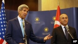 Menteri Luar Negeri Turki Mevlut Cavusoglu (kanan) dan Menlu AS John Kerry berbicara kepada media di Ankara, Turki (12/9/2014). Serangan ISIS telah memicu gelombang pengungsi ke perbatasan Turki. 