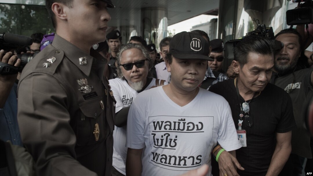 Dua pengunjuk rasa (berbaju putih) ditahan petugas polisi selama unjuk rasa di Bangkok tepat setahun lalu (AFP PHOTO/Nicolas Asfouri)