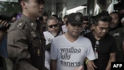 Dua pengunjuk rasa (berbaju putih) ditahan petugas polisi selama unjuk rasa di Bangkok tepat setahun lalu (AFP PHOTO/Nicolas Asfouri)