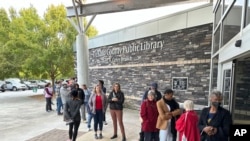 Des électeurs font la queue pour voter dans la banlieue d'Atlanta de Tucker, le mardi 15 octobre 2024, le premier jour du vote anticipé en personne en Géorgie. (AP Photo/Jeff Amy)