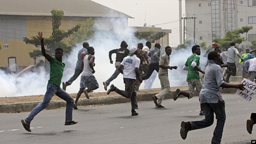 Protesters run away from tear gas fired by police officers during a demonstration against spiraling fuel prices in Lagos, Nigeria, January 16, 2012.
