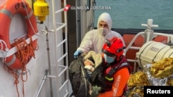 An Italian coastguard member holds a baby in his arms after a rescue operation of a boat in distress carrying migrants in the Mediterranean Sea, near Roccella Jonica, off Calabria coast, Italy. Taken 11.28.2021