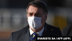 Le président brésilien Jair Bolsonaro portant un masque avant une réunion ministérielle au Palais Alvorada à Brasilia, pendant la pandémie de coronavirus, le 12 mai 2020. (Evaristo Sa/AFP)