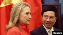 FILE - In this photo from July 2012, Vietnam's Foreign Minister Pham Binh Minh and then-U.S. Secretary of State Hillary Clinton prepare to walk to the meeting room at the Government Guest House in Hanoi.