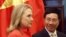 Vietnam's Foreign Minister Pham Binh Minh (R) looks at U.S. Secretary of State Hillary Clinton as they walk to the meeting room at the Government Guest House in Hanoi, July 10, 2012. 