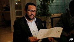 Libyan dissident Abdel Hakim Belhaj holds a letter of apology he received from British Prime Minister Theresa May, following a news conference in Istanbul, Turkey, May 10, 2018.