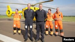 Pangeran William berpose dengan kru Ambulans Udara East Anglian di bandara Cambridge Airport, Inggris, 27 Juli, 2017. 