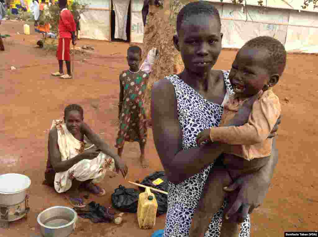 A South Sudanese woman carries her daughter in Kiryandongo settlement camp in northern Uganda.