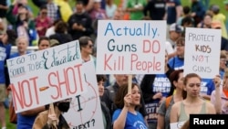 Demonstran memegang plakat saat mereka berunjuk rasa dalam 'March for Our Lives', salah satu dari serangkaian protes nasional terhadap kekerasan senjata, di Washington, D.C., AS, 11 Juni 2022. (Foto: REUTERS/Joshua Roberts)