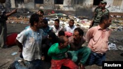 Suspects are rounded up near a burnt annex building of Rabaa Adawiya mosque after the clearing of a protest camp.