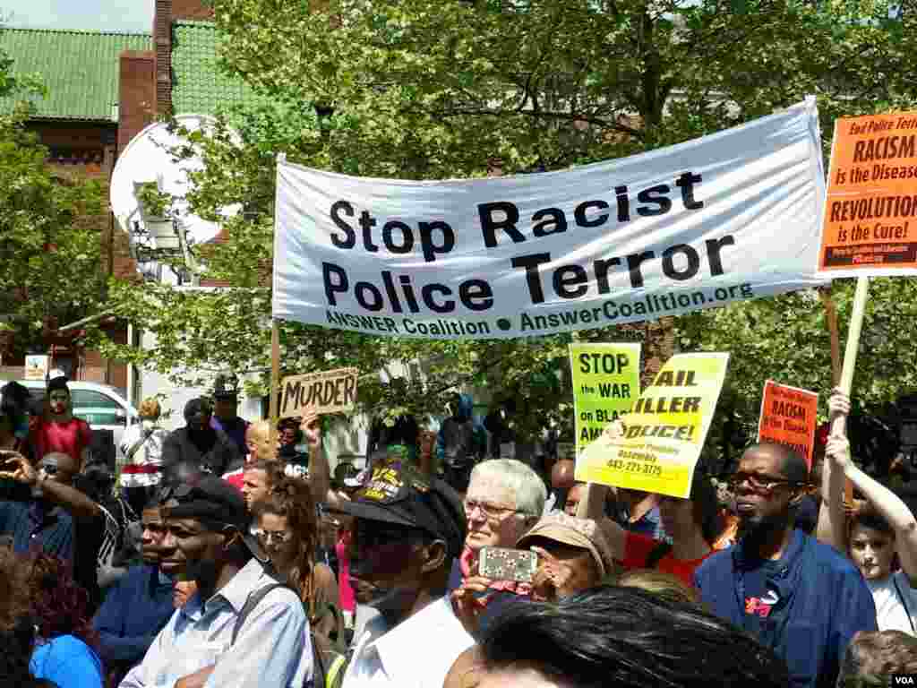 People march under a banner that reads "Stop Racist Police Terror," Baltimore, Maryland, May 2, 2015. (R. Muntu/VOA)