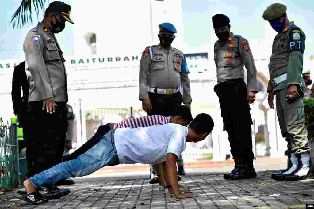 Men perform push-ups as punishment for not wearing face masks amid the Covid-19 coronavirus pandemic in Banda Aceh, Indonesia.