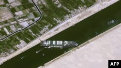 This handout satellite image courtesy of Cnes 2021 released on March 25, 2021, by Airbus DS shows the Taiwan-owned MV Ever Given container ship lodged sideways across the waterway of Egypt's Suez Canal. 
