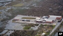 Se ve sedimento cubriendo parte del South Cameron High School en Creole, Luisiana, el viernes 28 de agosto de 2020, luego de que la marejada ciclónica retrocediera como consecuencia del huracán Laura.