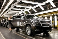 FILE - An employee inspects a Cadillac Escalade as it nears the final process of assembly at the General Motors plant in Arlington, Texas, July 14, 2015.