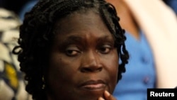 Ivory Coast's former first lady Simone Gbagbo (L) looks on as she attends the first day of her trial at the Palace of Justice in Abidjan December 26, 2014. Simone Gbagbo went on trial in Abidjan on Friday for her alleged role in stealing an election her h