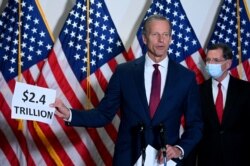 Senator John Thune (R-SD) holds a sign, which refers to the spending for the coronavirus relief bill, while speaking at a news conference at the U.S. Capitol in Washington, Oct. 20, 2020.