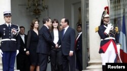 Mantan Presiden Nicolas Sarkozy (dua dari kiri) berjabat tangan dengan presiden baru Francois Hollande (kanan) di akhir upacara pelantikan presiden Perancis di Istana Elysee di Paris (15/5). 