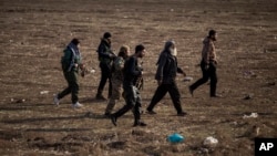 FILE - Kurdish-led fighters backed by the U.S. escort suspected Islamic State militants in Hasakah, Syria, Jan. 26, 2022. 