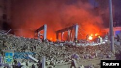 Petugas pemadam kebakaran bekerja di lokasi gedung administrasi yang rusak akibat serangan rudal Rusia, di tengah serangan Rusia ke Ukraina, di Dnipro, Ukraina, 28 Juli 2023. (Foto: via Reuters)