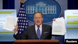 Juru bicara Gedung Putih Sean Spicer menunjukkan dokumen yang membandingkan Dewan Keamanan Nasional (NSC) pada pemerintahan Trump dan Obama (30/1). (Reuters/Kevin Lamarque)