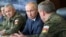 FILE - Russian President Vladimir Putin, center, and Russian Defense Minister Sergei Shoigu, left, observe the main stage of the Kavkaz-2020 strategic command-and-staff exercises at the Kapustin Yar training ground, Russia, Sept. 25, 2020.