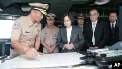 In this image from the Taiwan Presidential Office, Taiwan's President Tsai Ing-wen (center) reviews nautical charts aboard a Taiwan Navy ship before it sets out to patrol in the South China Sea from the naval base in the southern port city of Khaohsiung, Taiwan.