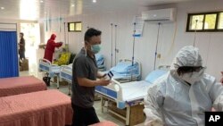 Tim polisi mengenakan APD memeriksa rumah sakit yang dilengkapi dengan tujuh tempat tidur di samping toko obat di Clark Freeport dan Zona Ekonomi Khusus barat laut Manila, 19 Mei 2020. (CIDG Regional Field Units 3 via AP)