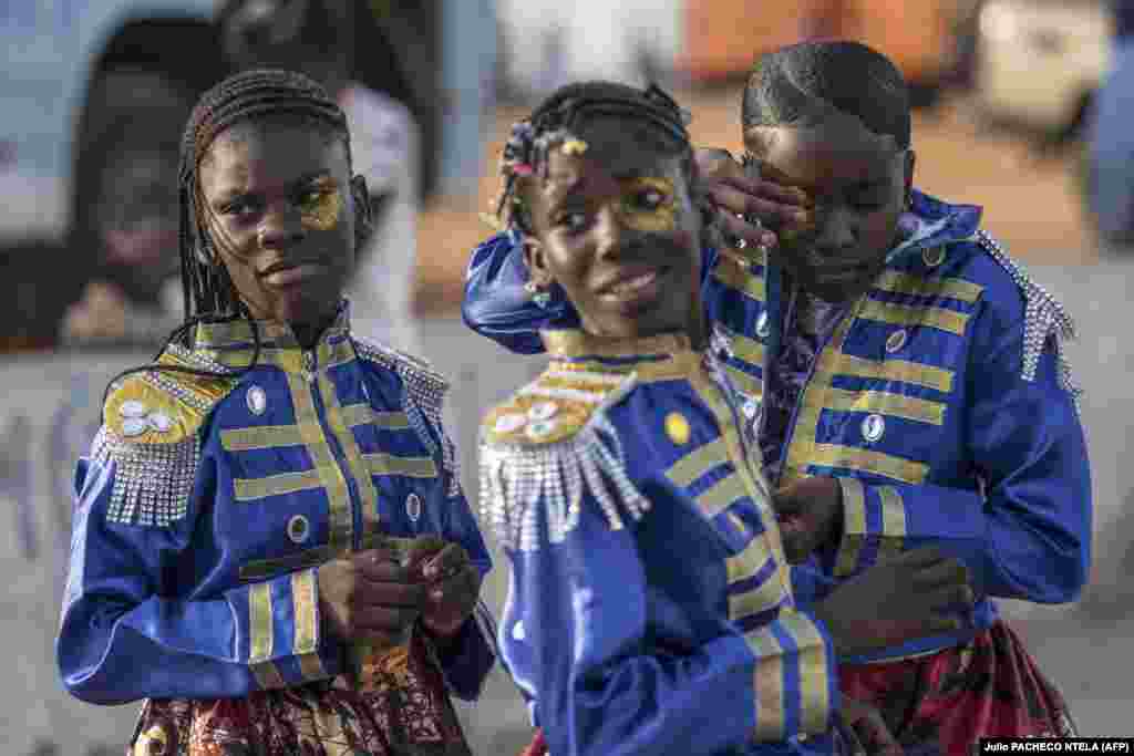 Menina coloca make-up antes de entrar para o desfile das crianças no primeiro dia de Carnaval de Luanda, 1 de março, 2025.