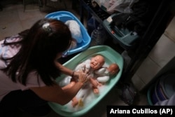 A volunteer washes recycled dolls to donate them to vulnerable children as Christmas presents, at the non-profit foundation Hospital of Stuffed Animals, in Caracas, Venezuela, Thursday, Dec. 5, 2024. (AP Photo/Ariana Cubillos)