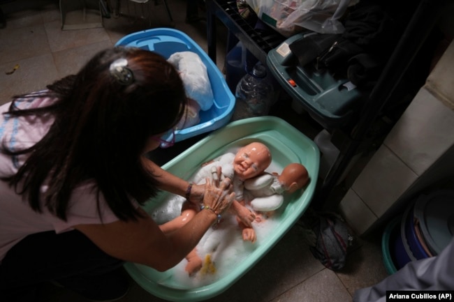 A volunteer washes recycled dolls to donate them to vulnerable children as Christmas presents, at the non-profit foundation Hospital of Stuffed Animals, in Caracas, Venezuela, Thursday, Dec. 5, 2024. (AP Photo/Ariana Cubillos)