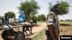 UNAMID peacekeeper Sergent Kindu Tarekegn, from Adigrat, Ethiopia, escorts a family that is returning home after farming outside Gereida, South Darfur, July 25, 2012. 