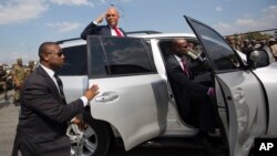 Haiti's outgoing President Michel Martelly delivers a goodbye salute to supporters before tucking into his vehicle outside the parliament building in Port-au-Prince, Haiti, Sunday, Feb. 7, 2016.