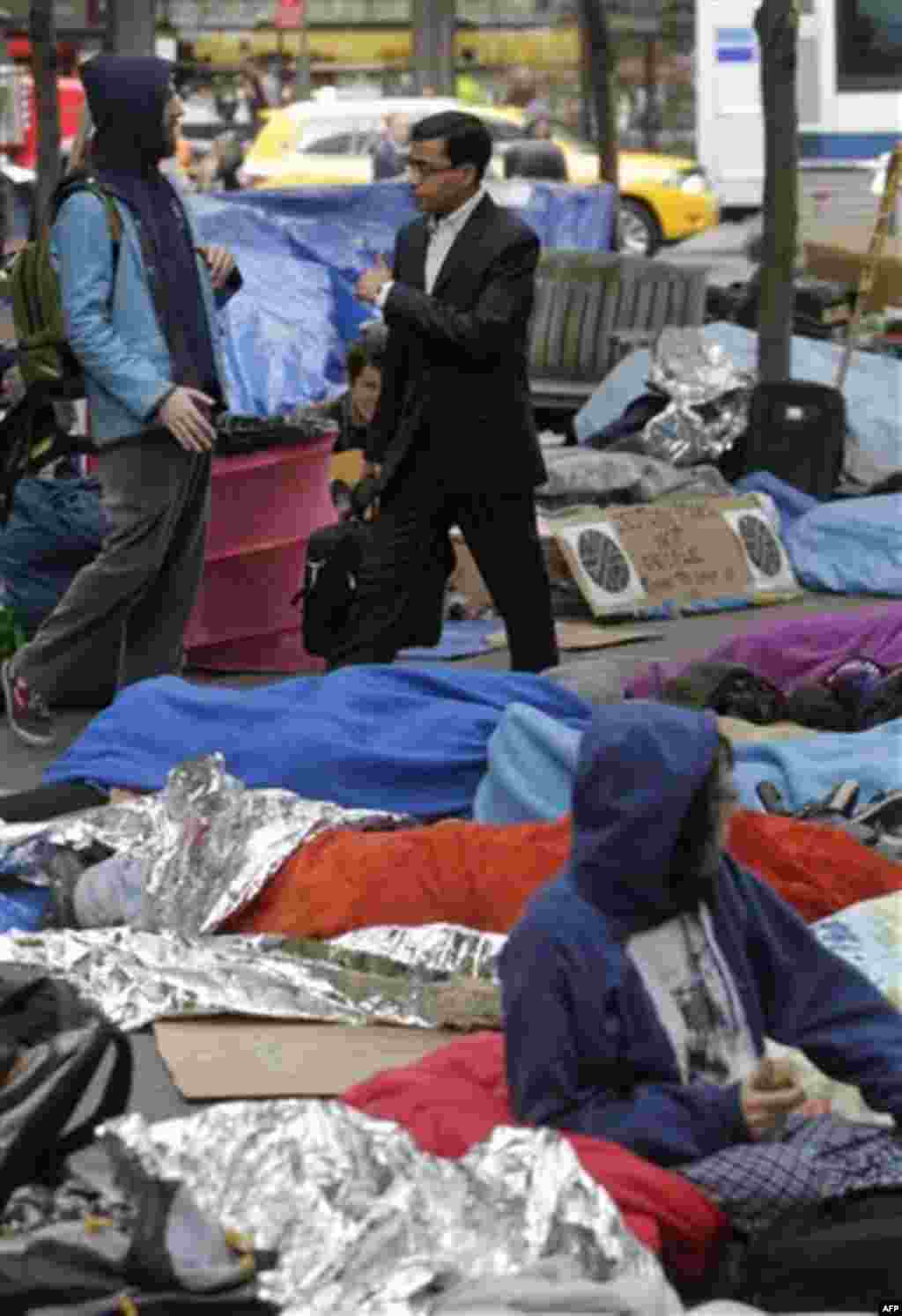 A commuter gives a thumbs-up to Occupy Wall Street protestors as he passes through Zuccotti Park in the financial district in New York, Tuesday, Oct. 4, 2011. The protests have gathered momentum and gained participants in recent days as news of mass arres