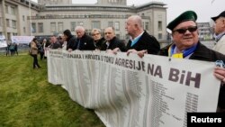 Bosnian survivors and family members gather outside the International Criminal Tribunal for former Yugoslavia (ICTY) ahead of the verdict in the genocide trial of former Bosnian Serb leader Radovan Karadzic, the Hague, the Netherlands, March 