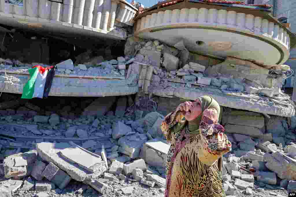 A Palestinian woman reacts outside a building that belonged to Montasser Shalabi, who was arrested in May on suspicion of carrying out a drive-by shooting attack on an Israeli student, after it was demolished by Israeli forces, in the occupied West Bank.