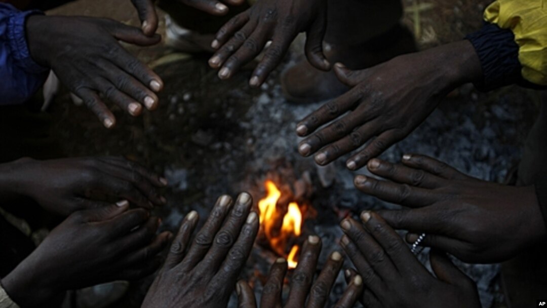 African migrants, displaced by anti-foreigner violence in Johannesburg, warm their hands around a small fire, May 2008 (file photo).