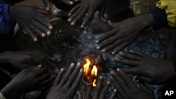 African migrants, displaced by anti-foreigner violence in Johannesburg, warm their hands around a small fire, May 2008 (file photo).