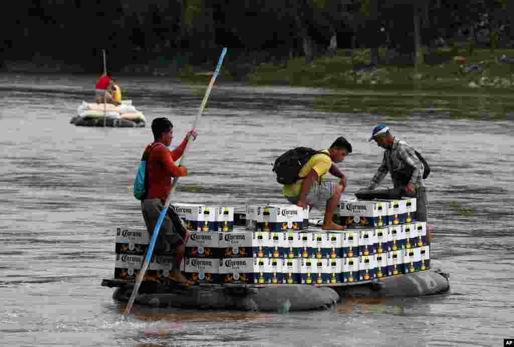Men cross the Suchiate Rivera with a load of Corona beer on an inner tube and plank raft, near Ciudad Hidalgo, Mexico, June 17, 2019, on the border with Guatemala.