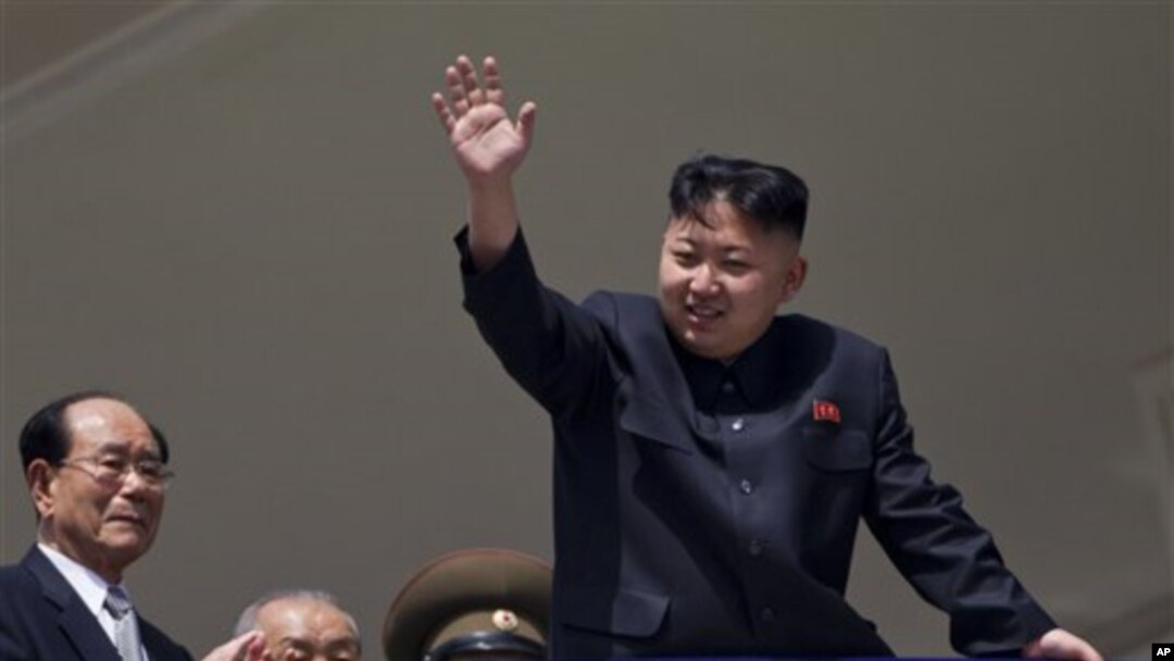 Pemimpin Korut, Kim Jong Un melambai kepada warga pada perayaan HUT ke-100 mendiang Kim Il Sung di Pyongyang, Minggu (15/4).