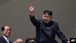 Pemimpin Korut, Kim Jong Un melambai kepada warga pada perayaan HUT ke-100 mendiang Kim Il Sung di Pyongyang, Minggu (15/4).