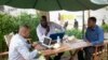 FILE - Men work on their laptops at the Endiro Cade in Kampala. 