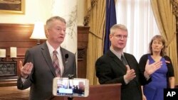 Idaho Gov. Brad Little, left, announces stricter guidelines for social interactions to slow the spread of the new coronavirus from the Statehouse in Boise, March 18, 2020. On March 25, 2020, Little issued a statewide stay-at-home order.