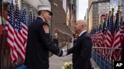 2023年9月11日，美国国土安全部部长马约卡斯在纽约参加911事件22周年的纪念活动上与一位消防员握手。（美联社）