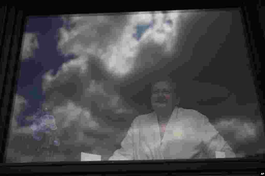 Diane Wanten, 61, poses for a portrait looking out of the window of the house of her son in Alken, Belgium, on April 29, 2020. Wanten was recently released into home quarantine after being treated for two weeks at the Jessa Hospital ICU ward for COVID-19.