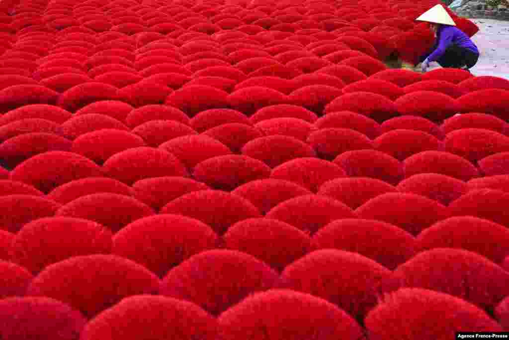 A worker collects dried incense sticks in a courtyard in Quang Phu Cau village on the outskirts of Hanoi ahead of Lunar New Year celebrations, known in Vietnam as Tet.