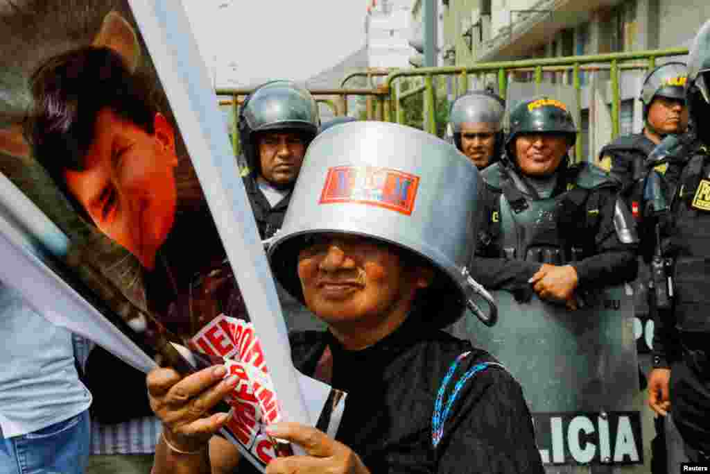 Un manifestante asiste a una protesta mientras los policías hacen guardia después de que el Congreso aprobara la destitución del presidente Pedro Castillo, en Lima, Perú, el 7 de diciembre de 2022. REUTERS/Alessandro Cinque