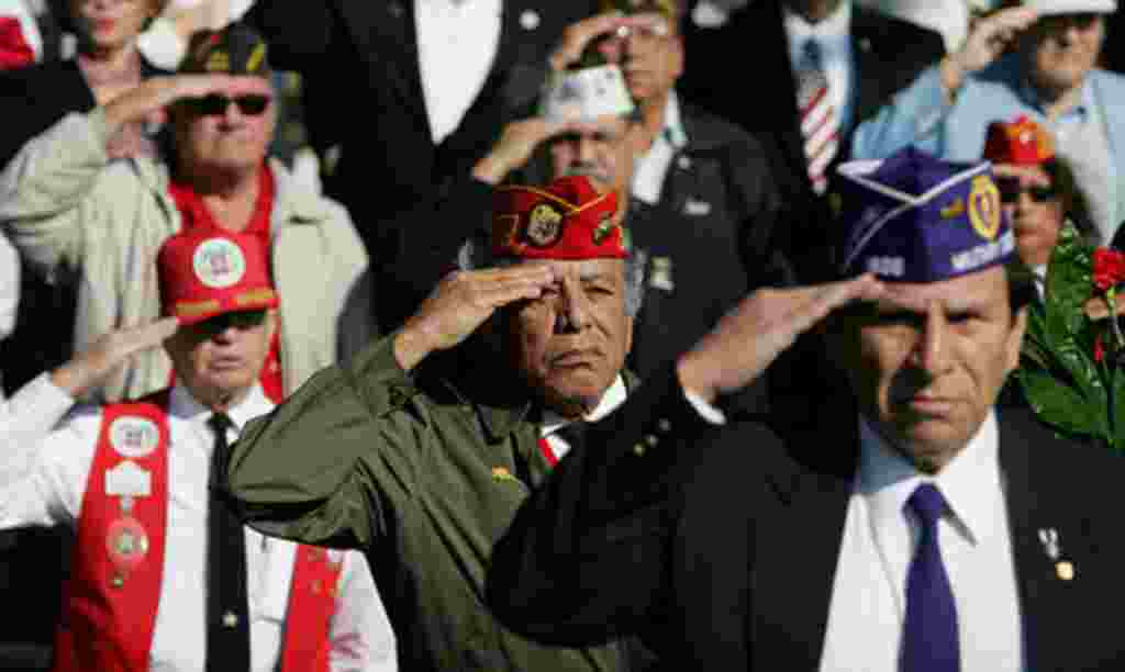 Los veteranos saludan la bandera durante una ceremonia del Día de los Veteranos en el Cementerio Nacional Fort Sam Houston en San Antonio.