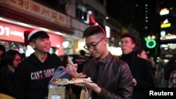 Protesters queue for a free Christmas dinner offered by a local restaurant in Hong Kong, Dec. 25, 2019.